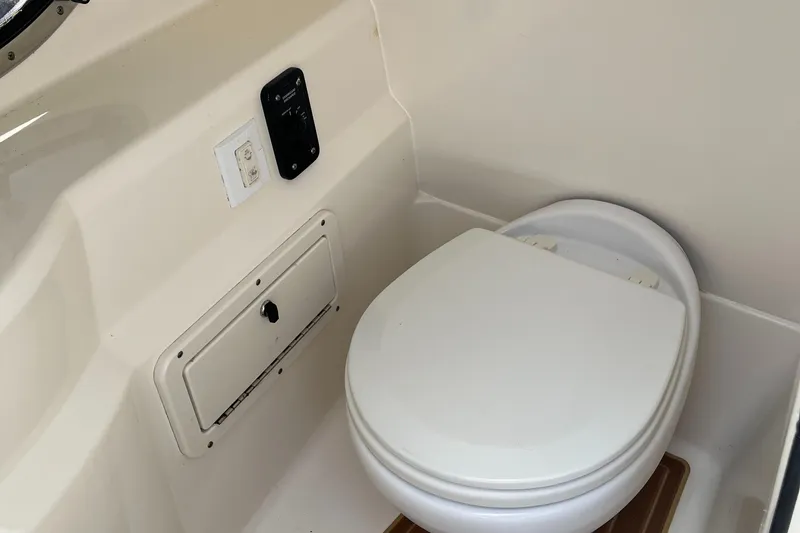 Slide: The Image of 2018 NauticStar 243DC Sport Deck boat interior with built-in toilet. - 24