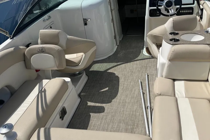 Slide: The Image of 2018 NauticStar 243DC Sport Deck interior with beige seating and modern dashboard. - 4