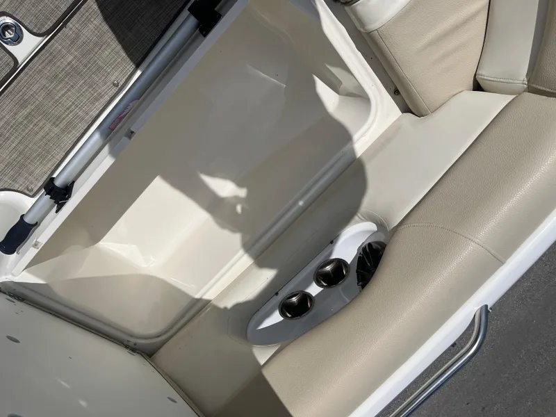 Slide: The Image of 2018 NauticStar 243DC Sport Deck interior with beige seating and cup holders. - 8