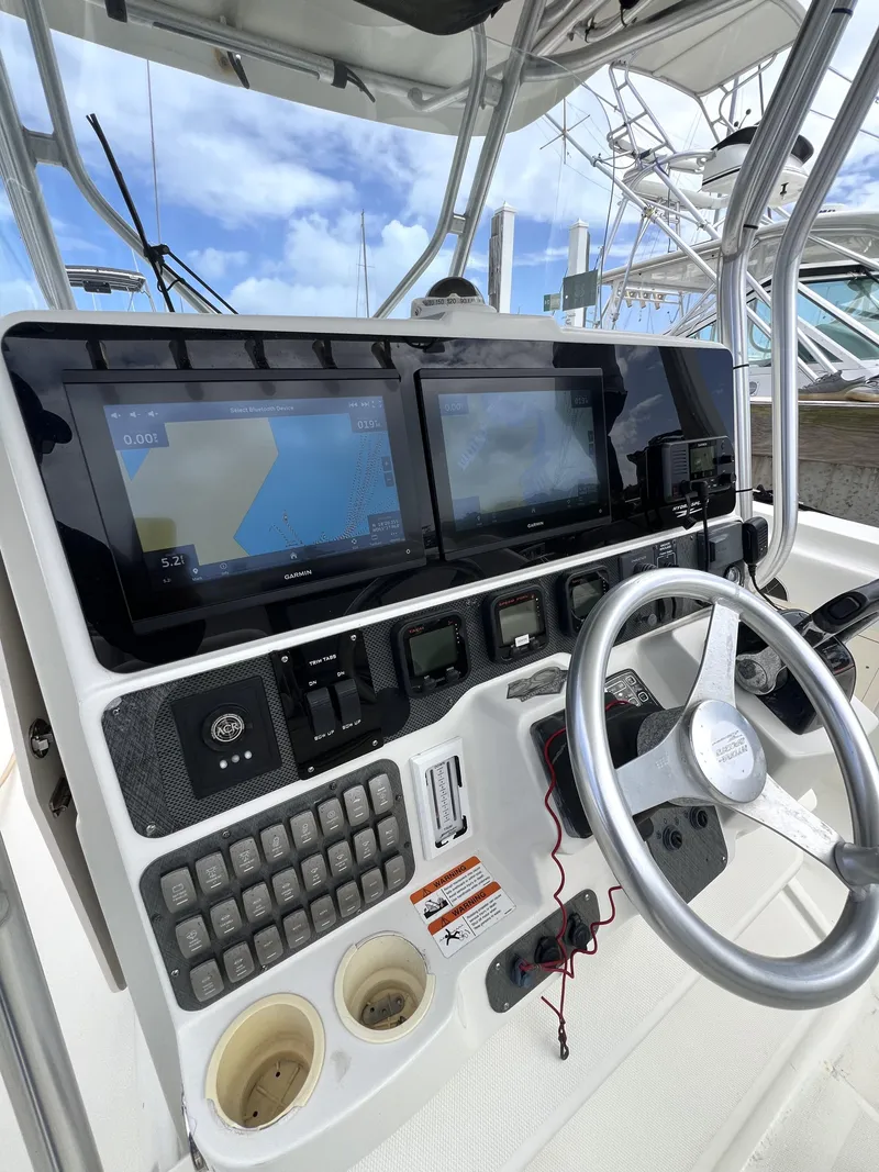 Slide: The Image of 2003 Hydra-Sports Vector 3300 CC boat dashboard with navigation screens and steering wheel. - 2