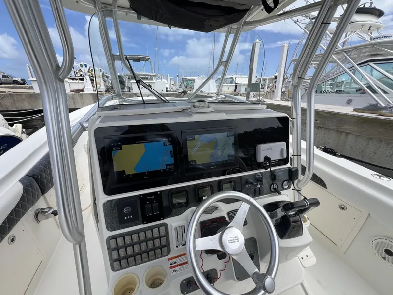 Slide: The Image of 2003 Hydra-Sports Vector 3300 CC boat dashboard with navigation screens and steering wheel. - 3