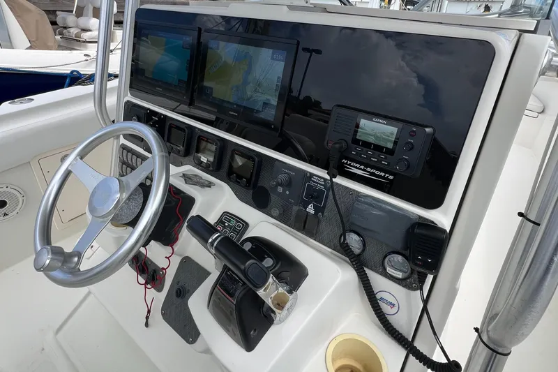 Slide: The Image of 2003 Hydra-Sports Vector 3300 CC helm with steering wheel, navigation screens, and controls. - 4