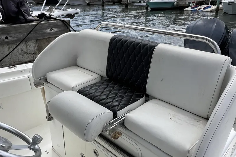Slide: The Image of 2003 Hydra-Sports Vector 3300 CC boat seating with black and white upholstery at a marina. - 8