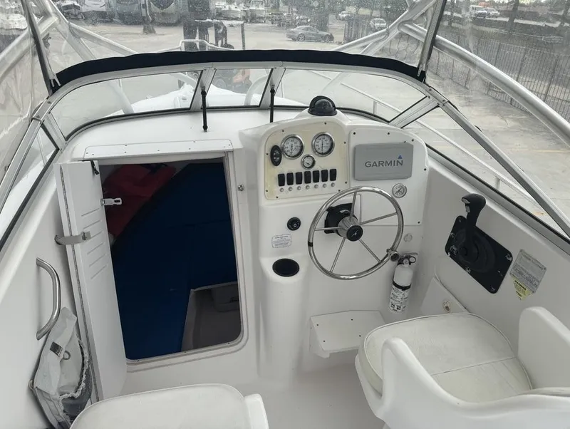 Slide: The Image of 2004 Pro-Line 22 Walk boat cockpit with Garmin navigation, steering wheel, and cabin entrance. - 13