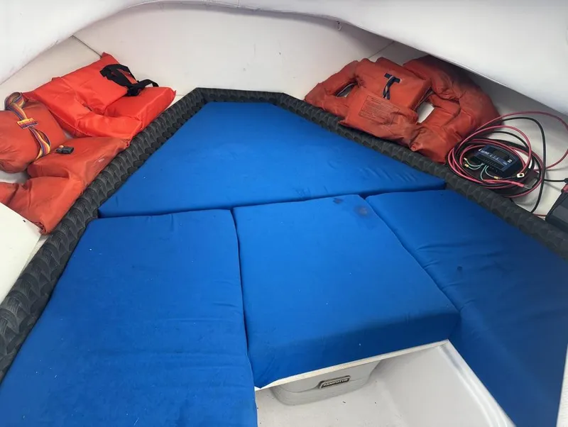 Slide: The Image of 2004 Pro-Line 22 Walk cabin interior with blue cushions and orange life jackets. - 14