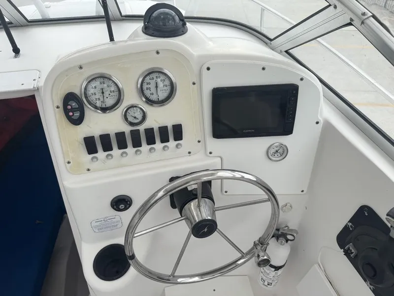 Slide: The Image of 2004 Pro-Line 22 Walk boat dashboard with steering wheel, gauges, and navigation system. - 6
