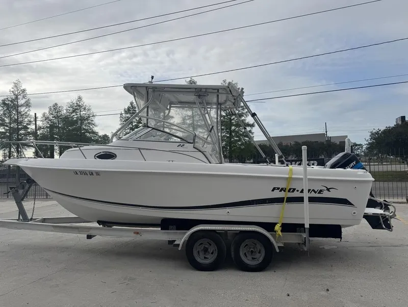 Slide: The Image of 2004 Pro-Line 22 Walk boat on trailer, side view, outdoors. - 9