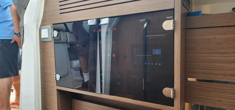 Slide: The Image of 2022 Jeanneau Leader 12.5 WA interior with modern wood paneling and control panel. - 18