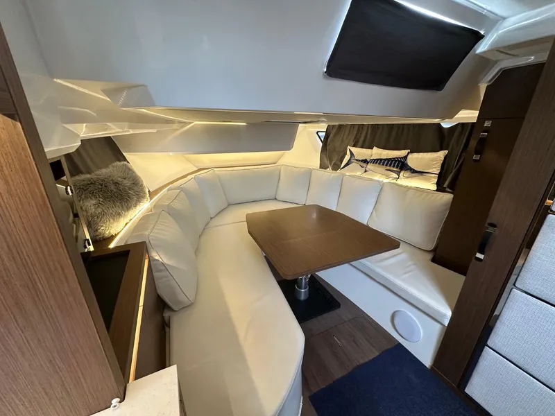 Slide: The Image of Luxurious interior of 2022 Jeanneau Leader 12.5 WA with plush seating and wooden table. - 26