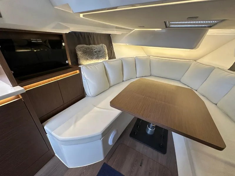 Slide: The Image of Luxurious interior of 2022 Jeanneau Leader 12.5 WA with plush seating and wooden table. - 27