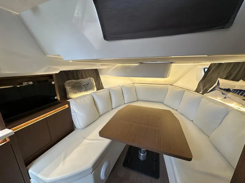 Slide: The Image of Luxurious interior of 2022 Jeanneau Leader 12.5 WA with white seating and wooden table. - 28