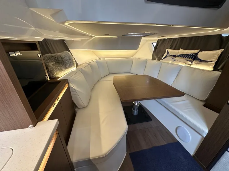 Slide: The Image of Luxurious interior of 2022 Jeanneau Leader 12.5 WA with plush seating and wooden table. - 30