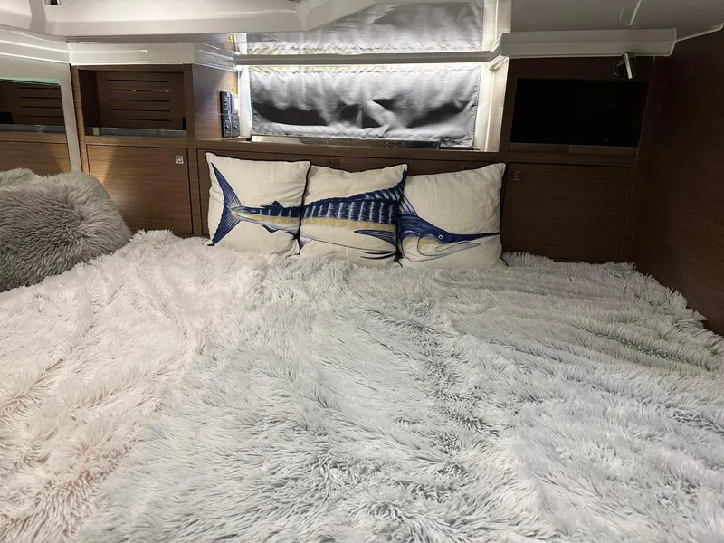 Slide: The Image of Cozy cabin interior of 2022 Jeanneau Leader 12.5 WA with plush bedding and fish-themed pillows. - 32