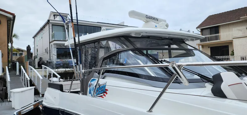 Slide: The Image of 2022 Jeanneau Leader 12.5 WA boat docked near waterfront homes. - 4