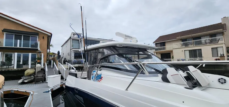 Slide: The Image of 2022 Jeanneau Leader 12.5 WA docked near waterfront homes under cloudy skies. - 5