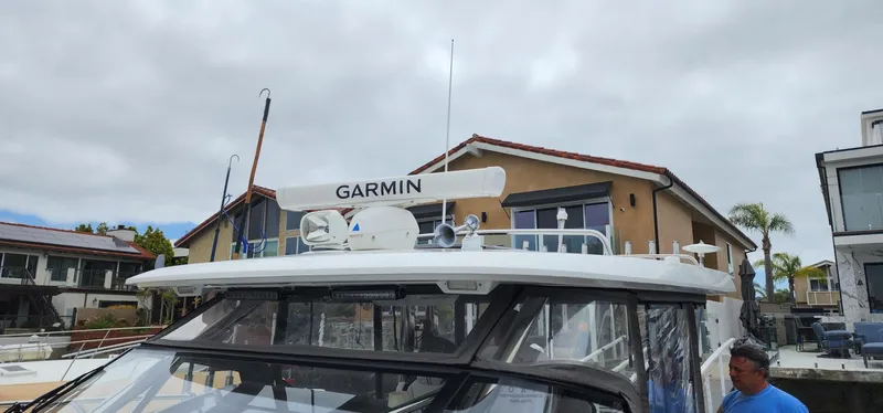 Slide: The Image of 2022 Jeanneau Leader 12.5 WA boat with Garmin equipment, docked near waterfront homes. - 6