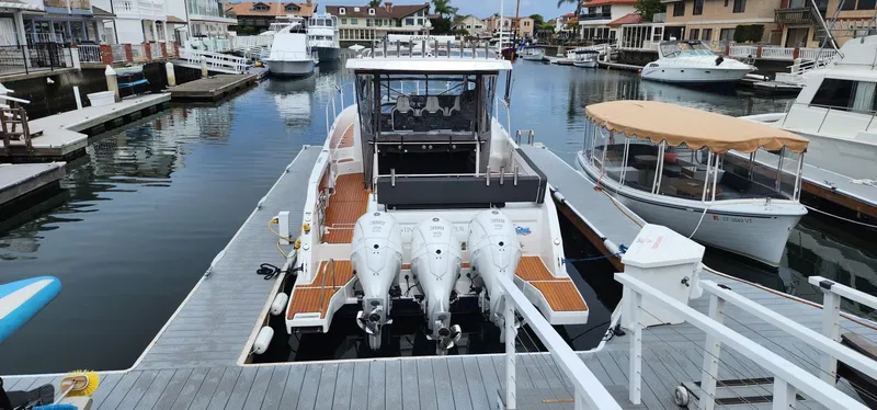 Slide: The Image of 2022 Jeanneau Leader 12.5 WA docked in a marina, featuring triple outboard engines. - 7