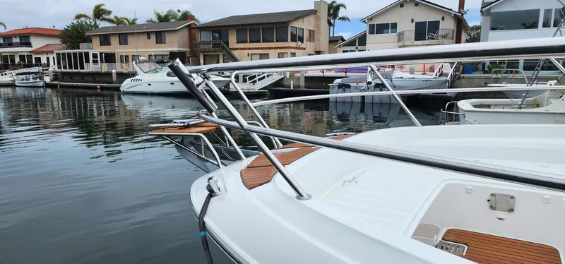 Slide: The Image of 2022 Jeanneau Leader 12.5 WA docked in a marina, surrounded by waterfront homes. - 8