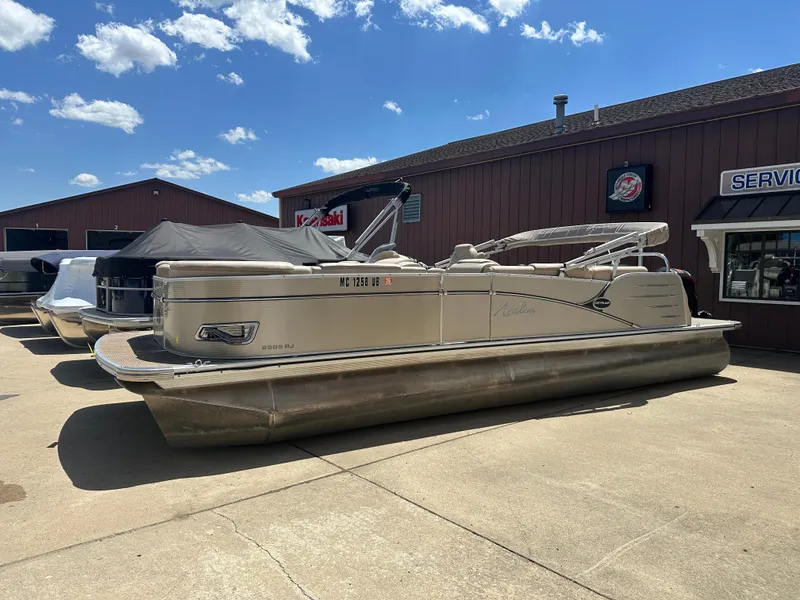 The Image of 2018 Avalon Catalina Cruise 25' pontoon boat parked outside dealership under blue sky. - 1