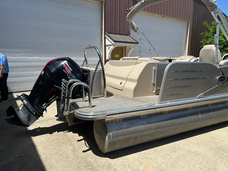Slide: The Image of 2018 Avalon Catalina Cruise 25' pontoon boat with outboard motor, parked near a garage. - 18