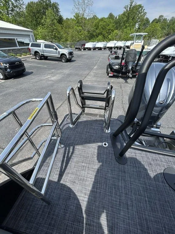 Slide: The Image of 2025 Godfrey Sweetwater 2286 SFLC boat with ladder and railing, parked outdoors. - 14