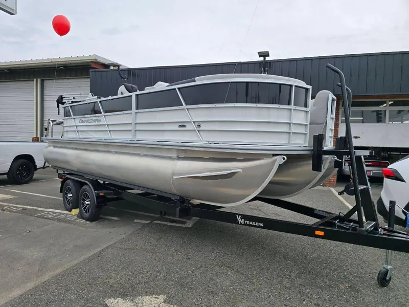 The Image of 2025 Berkshire 22 RFX LE pontoon boat on trailer, parked outdoors. - 0