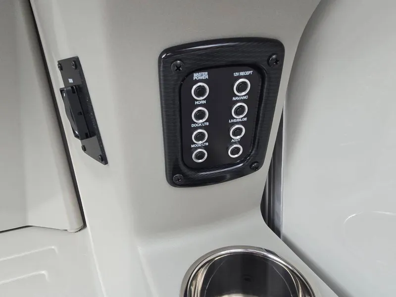 Slide: The Image of Control panel on 2025 Berkshire 22 RFX LE boat, featuring multiple switches and cup holder. - 25