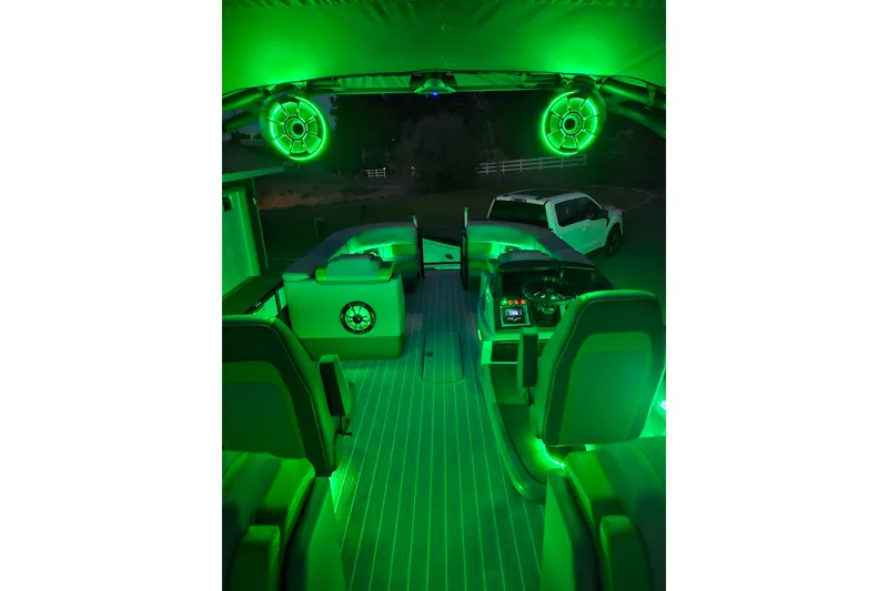 Slide: The Image of 2025 Berkshire 22 RFX LE boat interior with vibrant green LED lighting at night. - 27