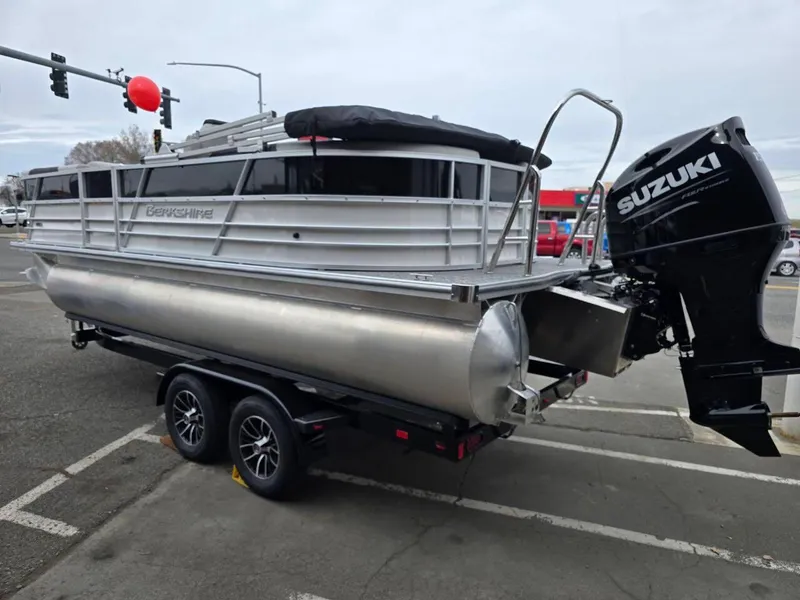 Slide: The Image of 2025 Berkshire 22 RFX LE pontoon boat with Suzuki outboard motor on trailer. - 5