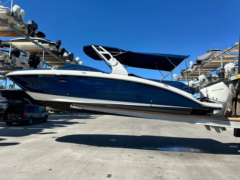 Slide: The Image of 2019 Sea Ray SDX 290 Outboard boat on a lift, blue hull, sunny day. - 20