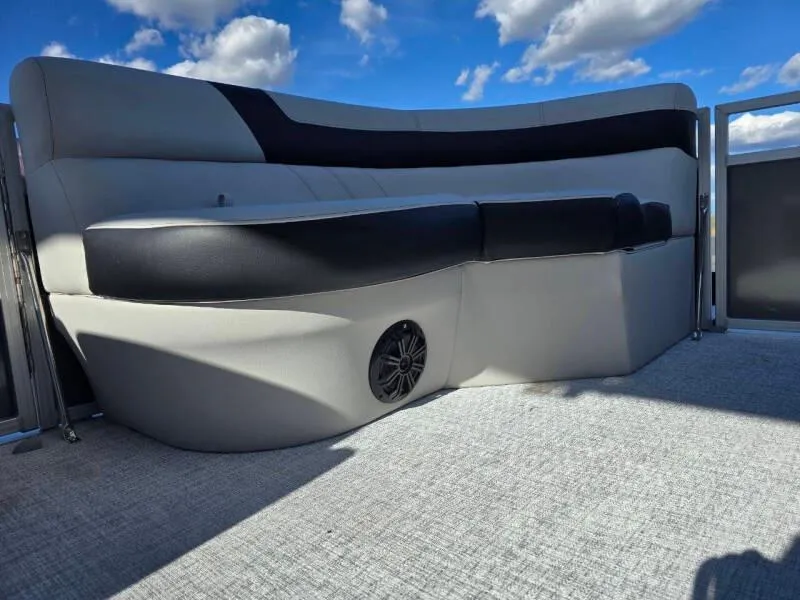 Slide: The Image of 2025 Berkshire 20 CL boat interior with cushioned seating and speaker, under a blue sky. - 15