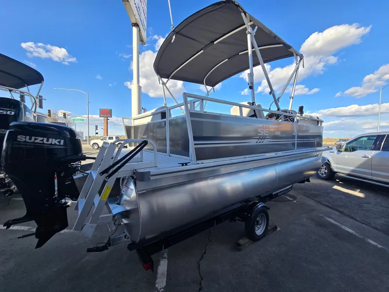 Slide: The Image of 2025 Berkshire 20 CL pontoon boat with canopy, parked outdoors under blue sky. - 3