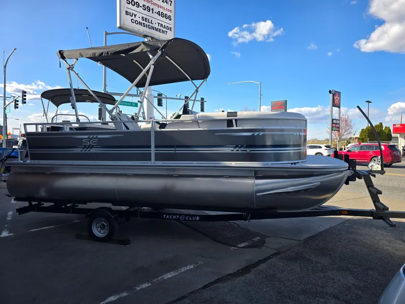 Slide: The Image of 2025 Berkshire 20 CL pontoon boat on trailer, parked outdoors under a blue sky. - 4
