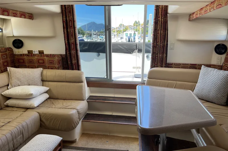 Slide: The Image of Interior of 1997 Carver 350 Mariner yacht with beige seating and table, marina view. - 17