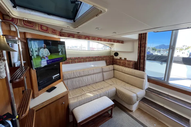 Slide: The Image of Interior of 1997 Carver 350 Mariner yacht with cozy seating and mounted TV. - 18
