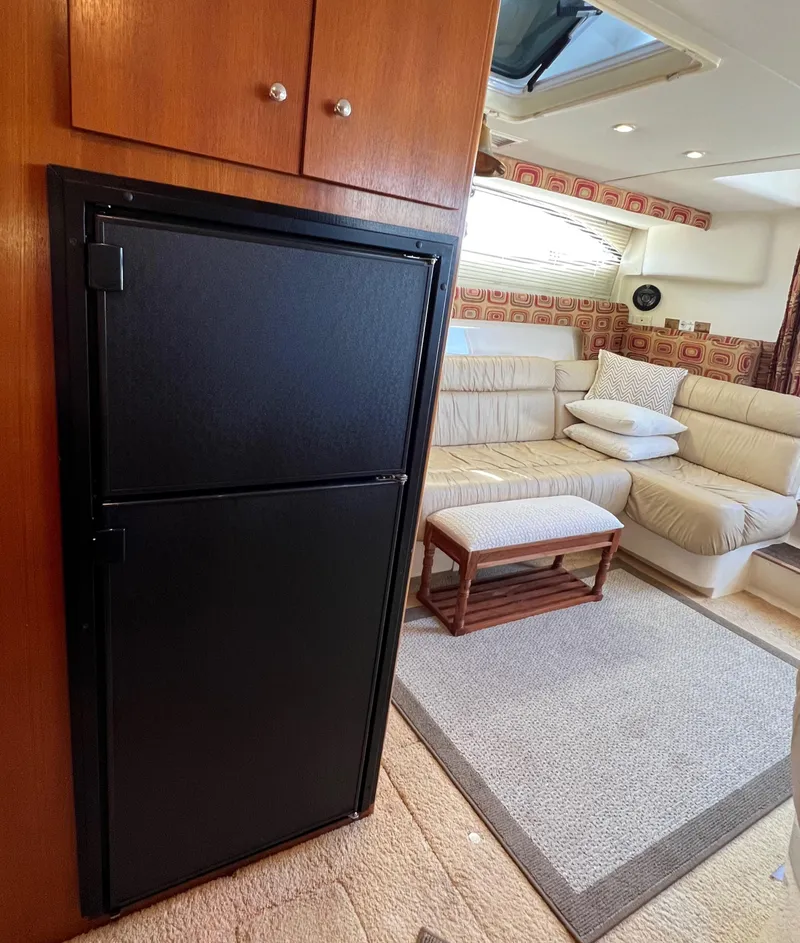 Slide: The Image of Interior of 1997 Carver 350 Mariner yacht with cozy seating and compact fridge. - 25