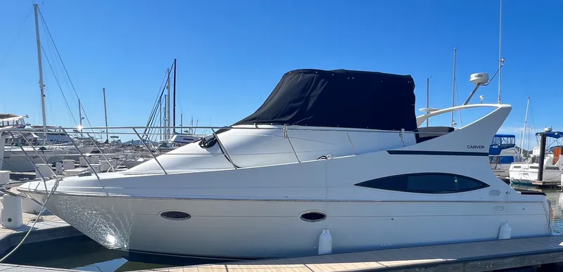 Slide: The Image of 1997 Carver 350 Mariner cruising on open water with scenic bridge view. - 5