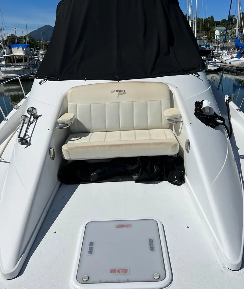 Slide: The Image of 1997 Carver 350 Mariner yacht with sliding glass doors and dual staircases, docked under clear skies. - 7