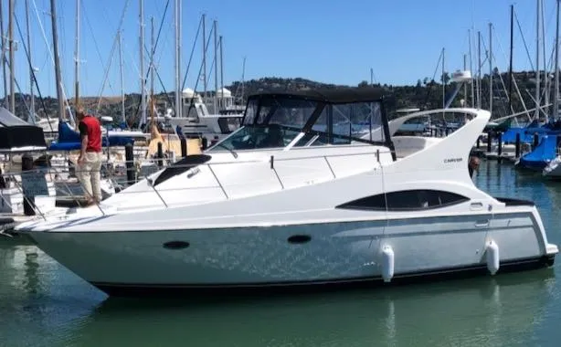 The Image of 1997 Carver 350 Mariner yacht cruising on a serene waterway, surrounded by lush greenery. - 0