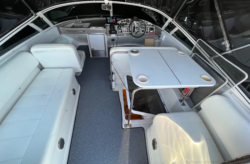 Slide: The Image of 1997 Carver 350 Mariner helm with marina view, featuring navigation equipment and steering wheel. - 12