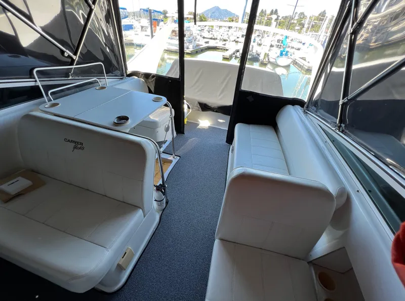 Slide: The Image of 1997 Carver 350 Mariner interior with white seating, table, and marina view. - 15