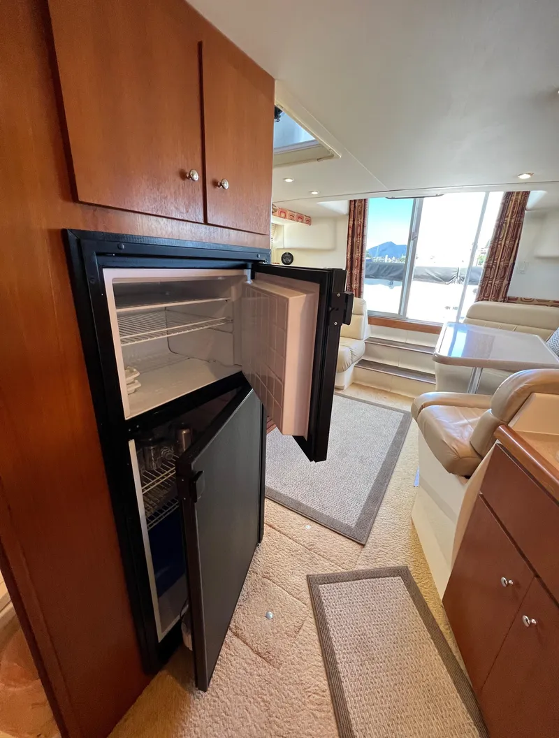 Slide: The Image of Interior of 1997 Carver 350 Mariner yacht with open fridge and seating area. - 21