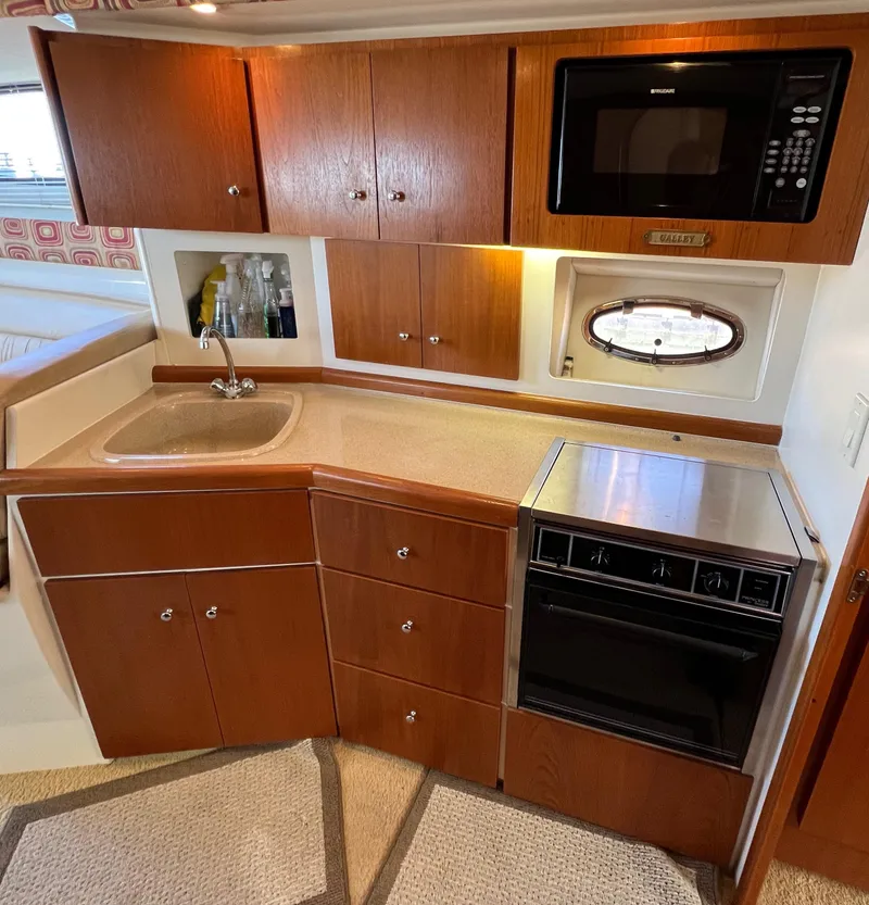 Slide: The Image of 1997 Carver 350 Mariner kitchen with wood cabinets, sink, oven, and microwave. - 22