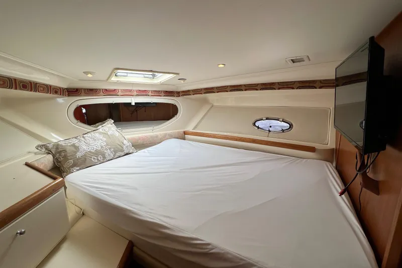 Slide: The Image of Interior of 1997 Carver 350 Mariner yacht with bed, pillows, and porthole window. - 26