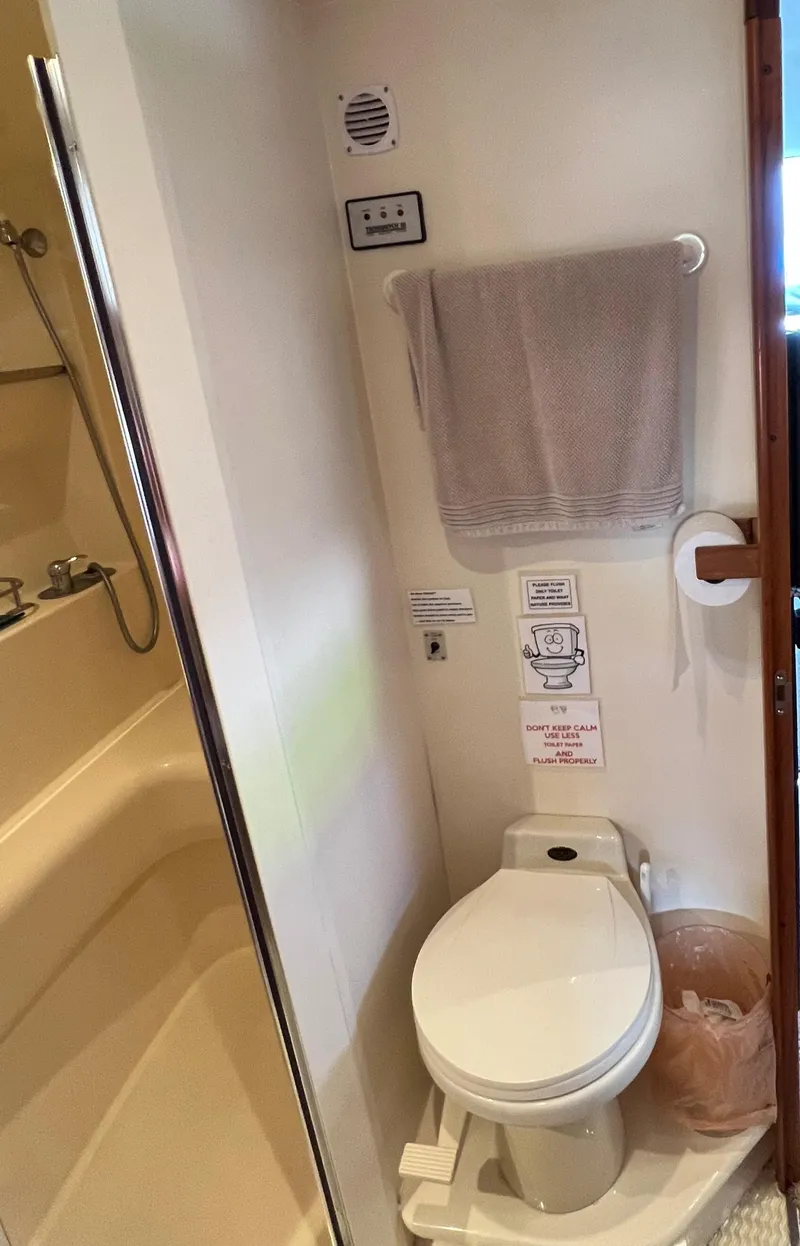 Slide: The Image of 1997 Carver 350 Mariner bathroom with toilet, towel rack, and shower area. - 29