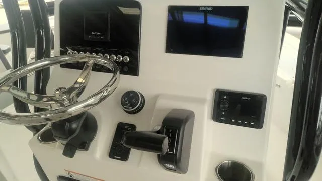 Slide: The Image of Control panel of 2025 Sea Pro 230 Bay boat with steering wheel and electronic displays. - 11