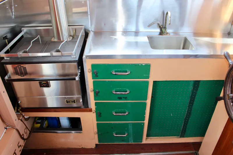 Slide: The Image of 1961 Custom 32' William Garden Tug kitchen with stainless steel sink and green cabinets. - 18