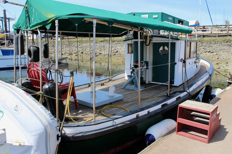 Slide: The Image of 1961 Custom 32' William Garden Tugboat docked with green canopy and wooden deck. - 3