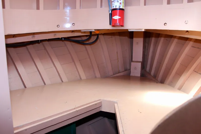 Slide: The Image of Interior of 1961 Custom 32' William Garden Tug, featuring wooden paneling and fire extinguisher. - 32