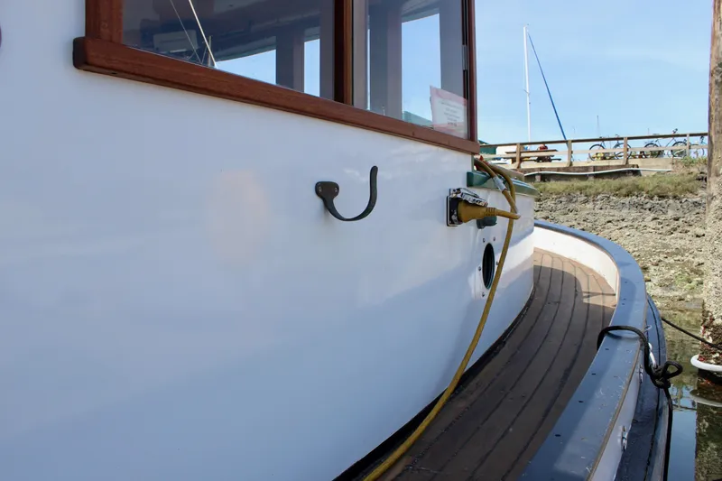 Slide: The Image of 1961 Custom 32' William Garden Tugboat, docked with visible wooden deck and cabin details. - 5